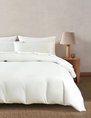 White Egyptian cotton bedding set on a minimalist bed, reflecting clean luxury and soft texture.